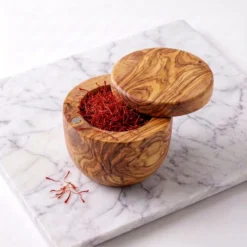 Boîte pivotante en bois d’olivier ouverte et remplie de filaments de safran