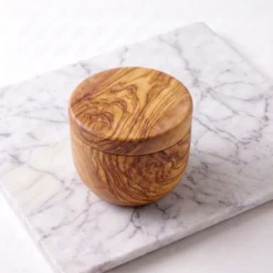 Closed olive wood swivel-lid cellar on light marble