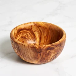 Bol rond en bois d’olivier vide sur une surface en marbre blanc