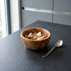 Round olive wood bowl with cereal and pear pieces