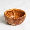 Empty round olive wood bowl on a white marble surface