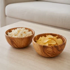 Deux saladiers en bois d’olivier de 20 cm contenant du popcorn et des chips pour l’apéritif