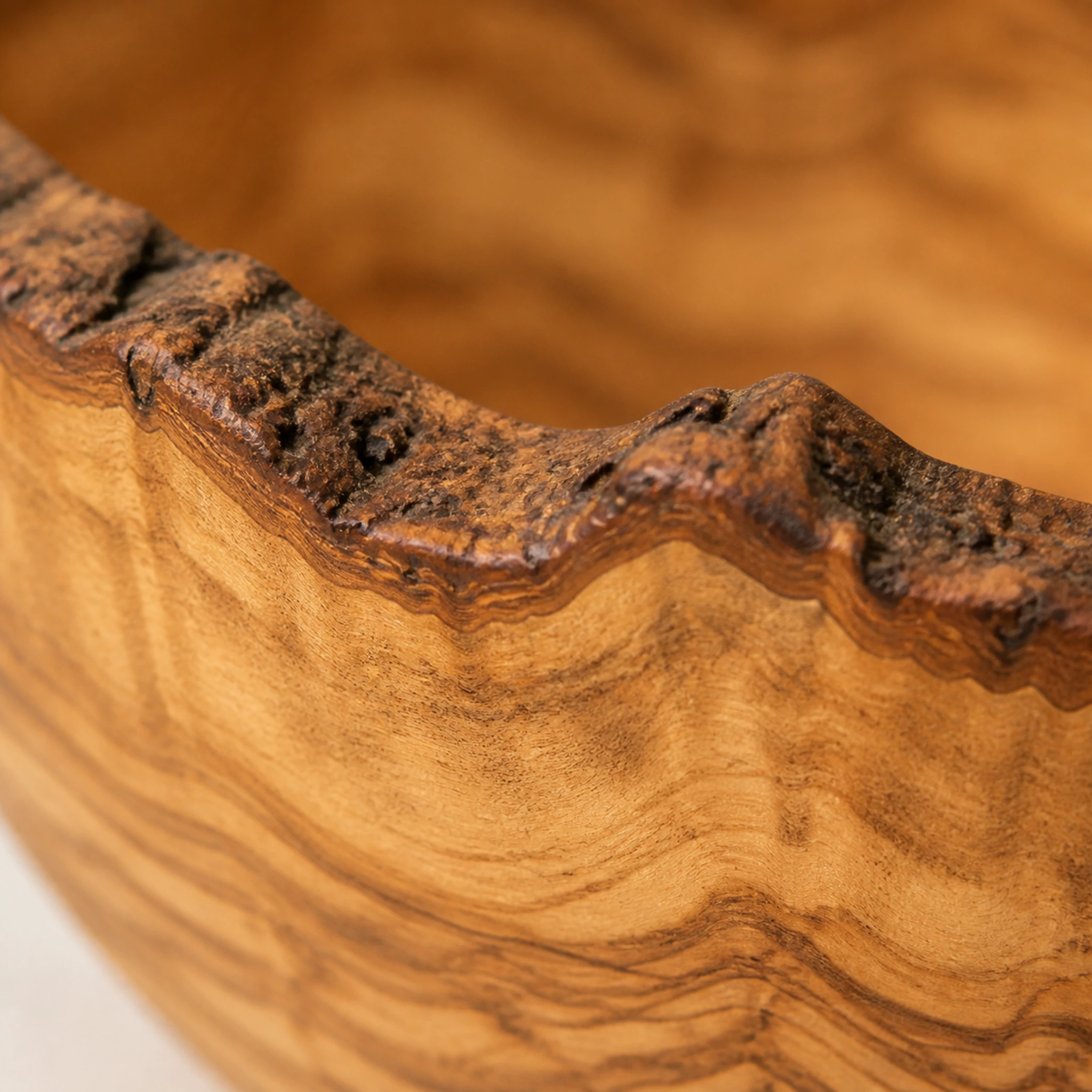 Détail du bord vivant et du veinage d’un très grand saladier rustique en bois d’olivier