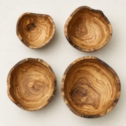 Vue de dessus de quatre saladiers rustiques en bois d’olivier de tailles différentes
