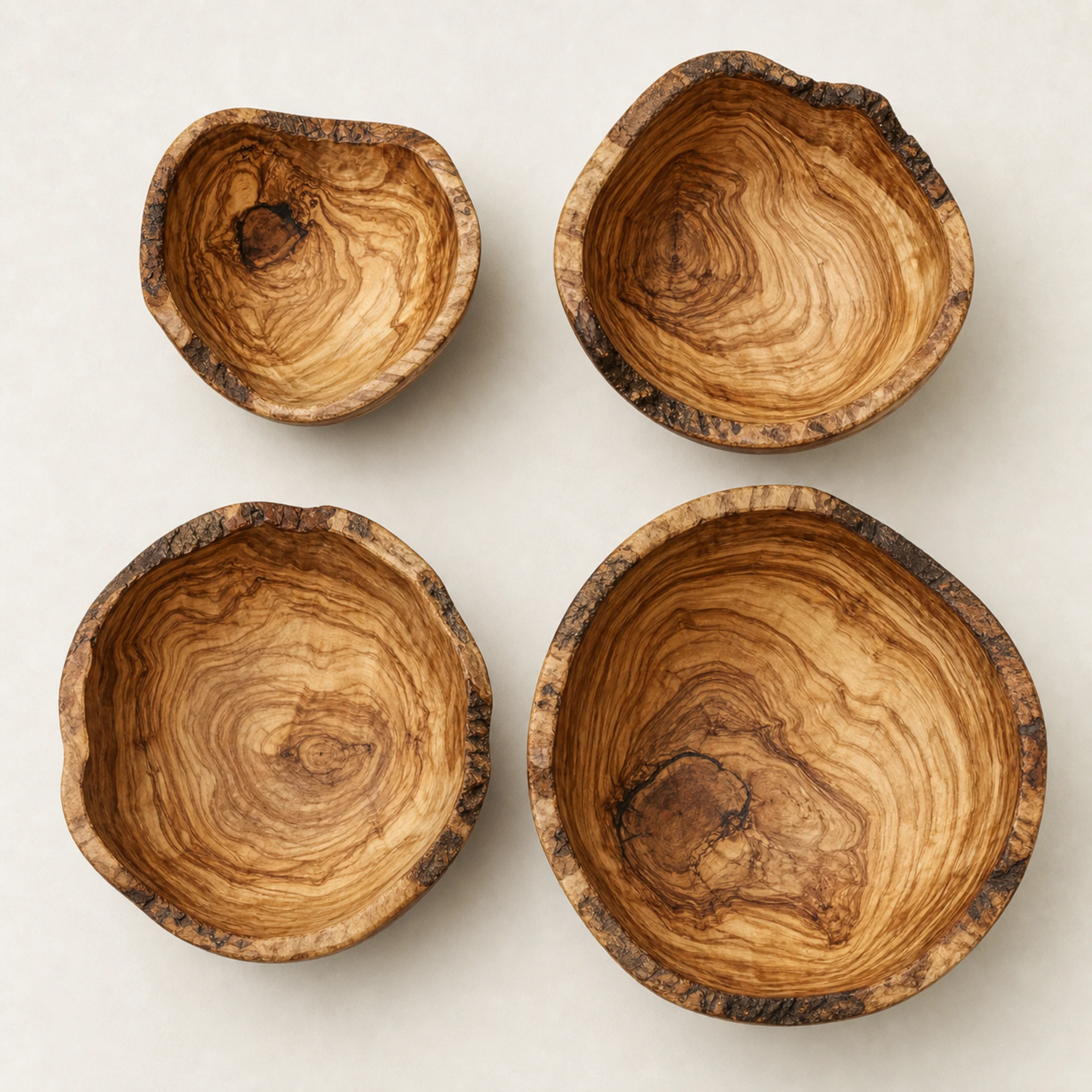 Vue de dessus de quatre saladiers rustiques en bois d’olivier de tailles différentes