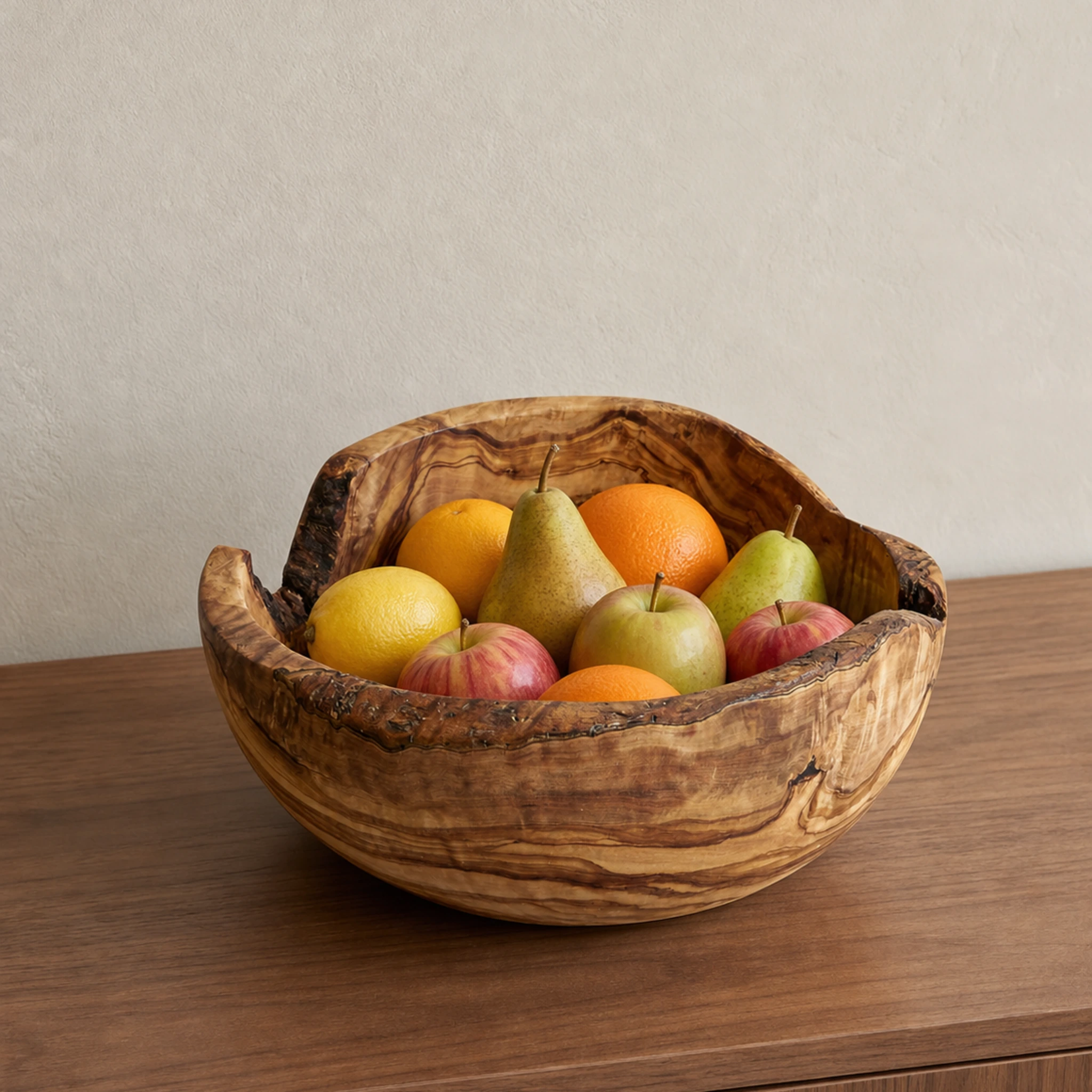 Saladier rustique en bois d’olivier rempli de fruits sur un meuble en bois