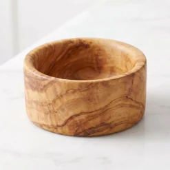 Empty olive wood snack bowl on white marble