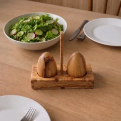 Salière et poivrière en bois d’olivier avec support près d’un saladier