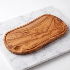 Planche rectangulaire en bois d’olivier avec rainure, vue de trois quarts sur marbre blanc