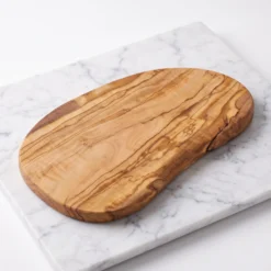 Planche ovale en bois d’olivier vide, vue de trois quarts sur marbre blanc