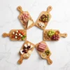 Six planches en bois d’olivier garnies pour l’apéritif et disposées en cercle
