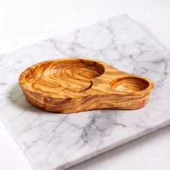 Plat apéritif artisanal à 2 compartiments en bois d’olivier sur plan de travail en marbre blanc