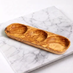 Plat apéritif artisanal à 3 compartiments en bois d’olivier sur plan de travail en marbre blanc