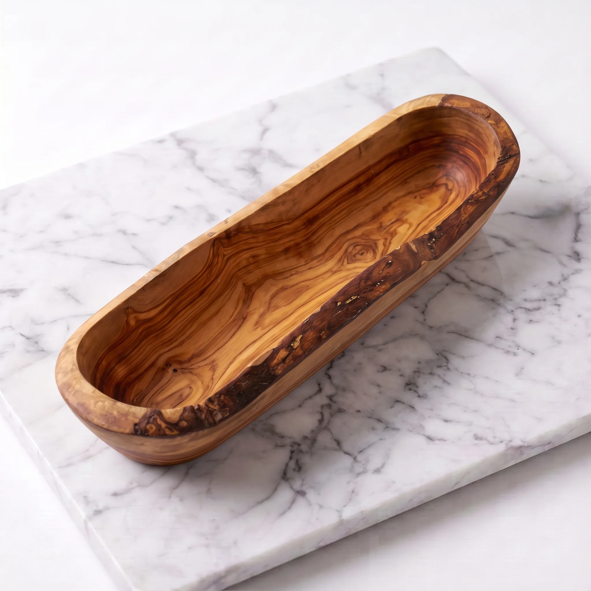Empty elongated olive wood bowl shown in a three-quarter view