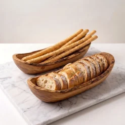 Deux corbeilles en bois d’olivier garnies de pain et de grissini