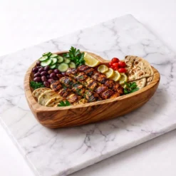 Plat cœur en bois d’olivier garni pour l’apéritif sur une table dressée