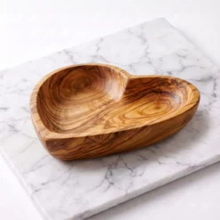Plat cœur artisanal en bois d’olivier sur plan de travail en marbre blanc