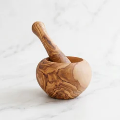 Mortier et pilon en bois d’olivier sur marbre blanc
