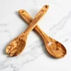 Paire de couverts à salade en bois d’olivier croisés sur marbre blanc