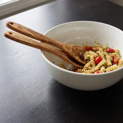 Couverts à salade en bois d’olivier dans un bol de salade de pâtes