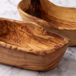 Close-up of the natural grain and contours of two olive wood tapas bowls