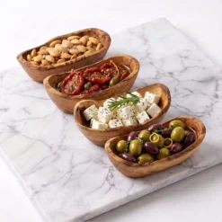 Quatre raviers à tapas en bois d’olivier garnis d’amandes, tomates, feta et olives