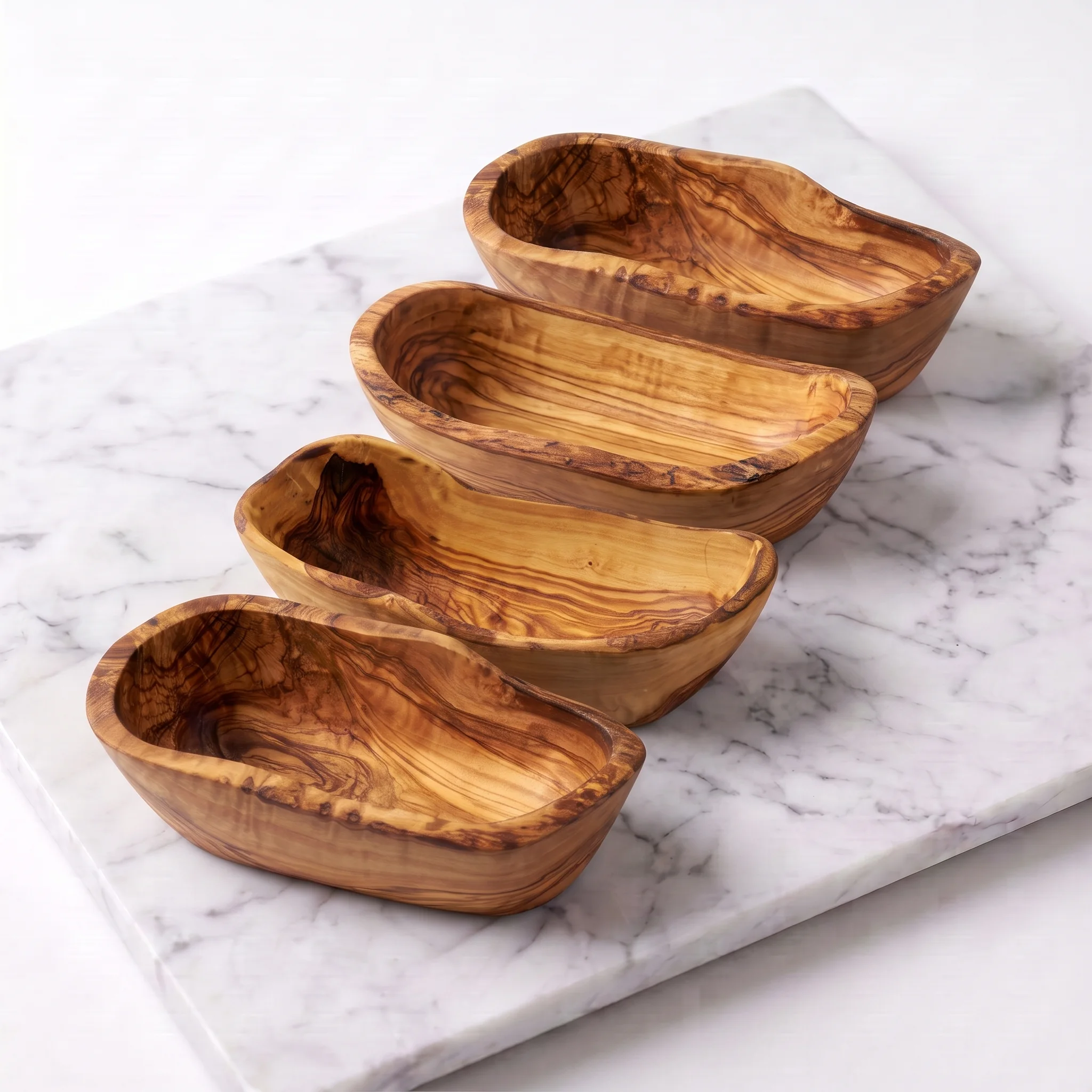 Four empty olive wood tapas bowls arranged in a studio view
