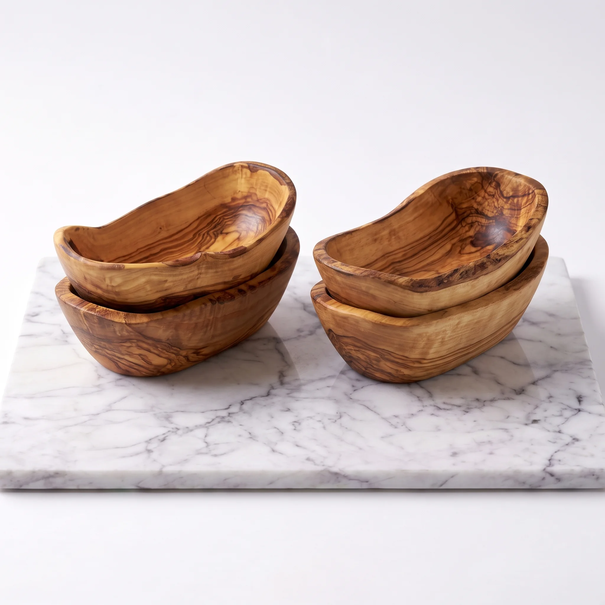 Four empty olive wood tapas bowls displayed in two stacked pairs