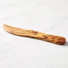 Olive wood butter spreader on white marble