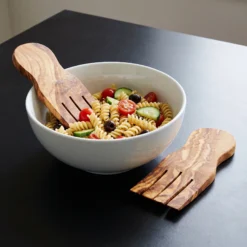 Mains à salade en bois d’olivier avec une salade de pâtes