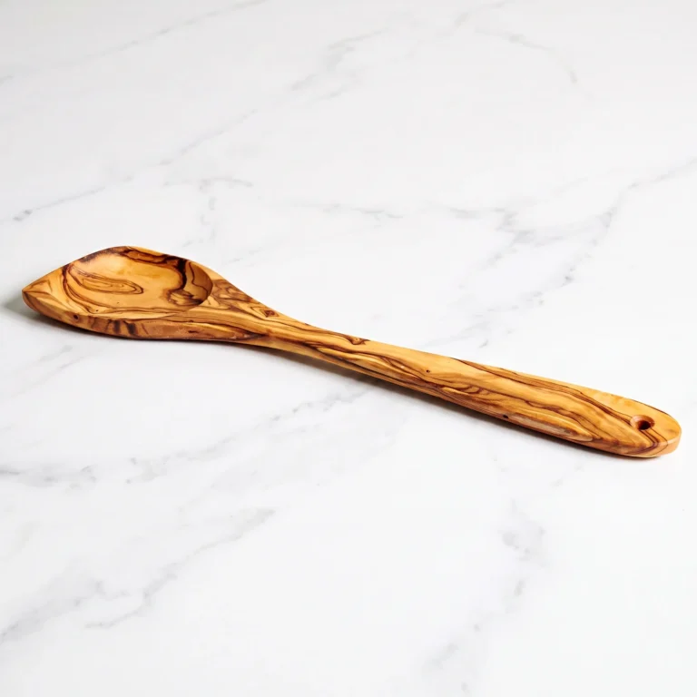 Olive wood mixing spoon on white marble