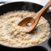 Slotted olive wood risotto spoon used while stirring risotto