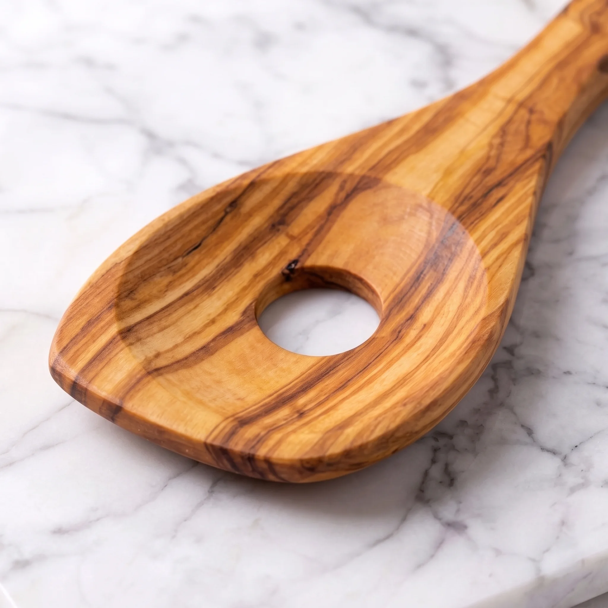 Close-up of the slotted head and grain of the olive wood risotto spoon