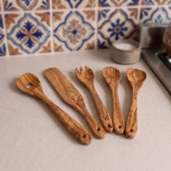 Cinq ustensiles en bois d'olivier en ambiance cuisine