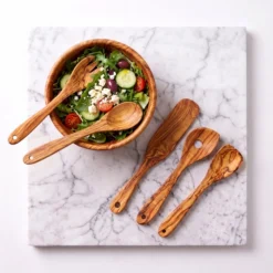 Cinq ustensiles en bois d'olivier avec salade préparée