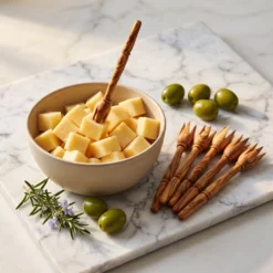 Six pics en bois d’olivier présentés avec des cubes de fromage pour illustrer leur usage