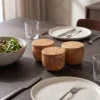 Trois boîtes à épices fermées en bois d’olivier présentées sur une table dressée