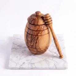 Pot à miel en bois d’olivier avec cuillère posée contre le pot