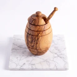 Pot à miel en bois d’olivier avec cuillère sur fond marbré