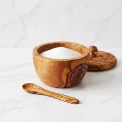 Open olive wood sugar bowl filled with white sugar