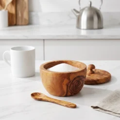 Open olive wood sugar bowl on a kitchen worktop