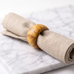Serviette en tissu maintenue par un rond en bois d’olivier