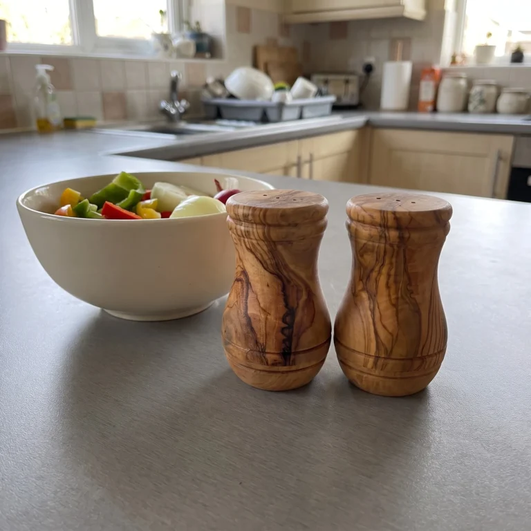 Olive wood salt and pepper shakers on a kitchen worktop