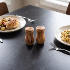 Salière et poivrière en bois d’olivier pendant un repas à table